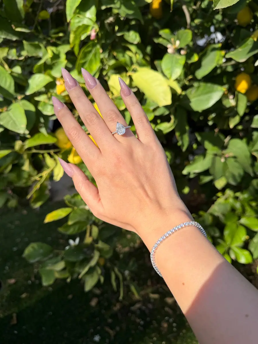 טבעת טיפה מכסף 925 משובצת זירקונים על יד של דוגמנית בטבע